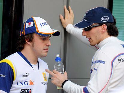 Fernando Alonso conversa con Robert Kubica ayer en el circuito de Melbourne.