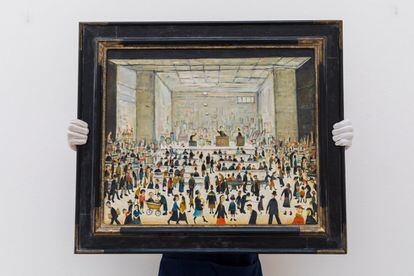 Se espera que el precio de la pintura de 1958 del artista de Lancashire, en Reino Unido, ronde las 1,8 millones de libras (más de dos millones de euros) el próximo mes. La imagen muestra una bulliciosa casa de subastas atestada de personas.