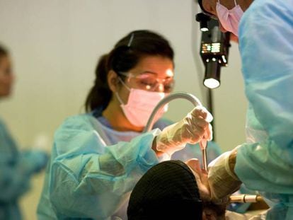 Odontólogos tratando a un paciente. 