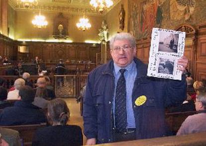Un descendiente de judíos deportados de Francia muestra fotos de un familiar durante el juicio a Brunner.