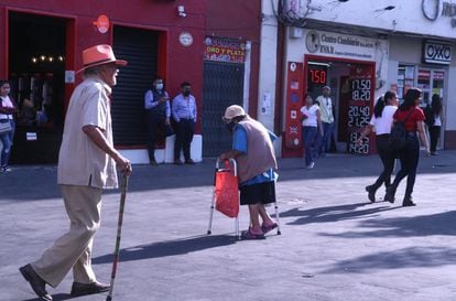 Dos adultos de la tercera edad caminan sobre un paseo peatonal en Cuernavaca, en el Estado de Morelos, el 8 de marzo de 2023.