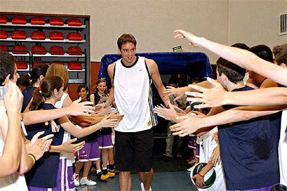 El jugador de baloncesto Pau Gasol saluda a niños en la localidad de Tres Cantos.