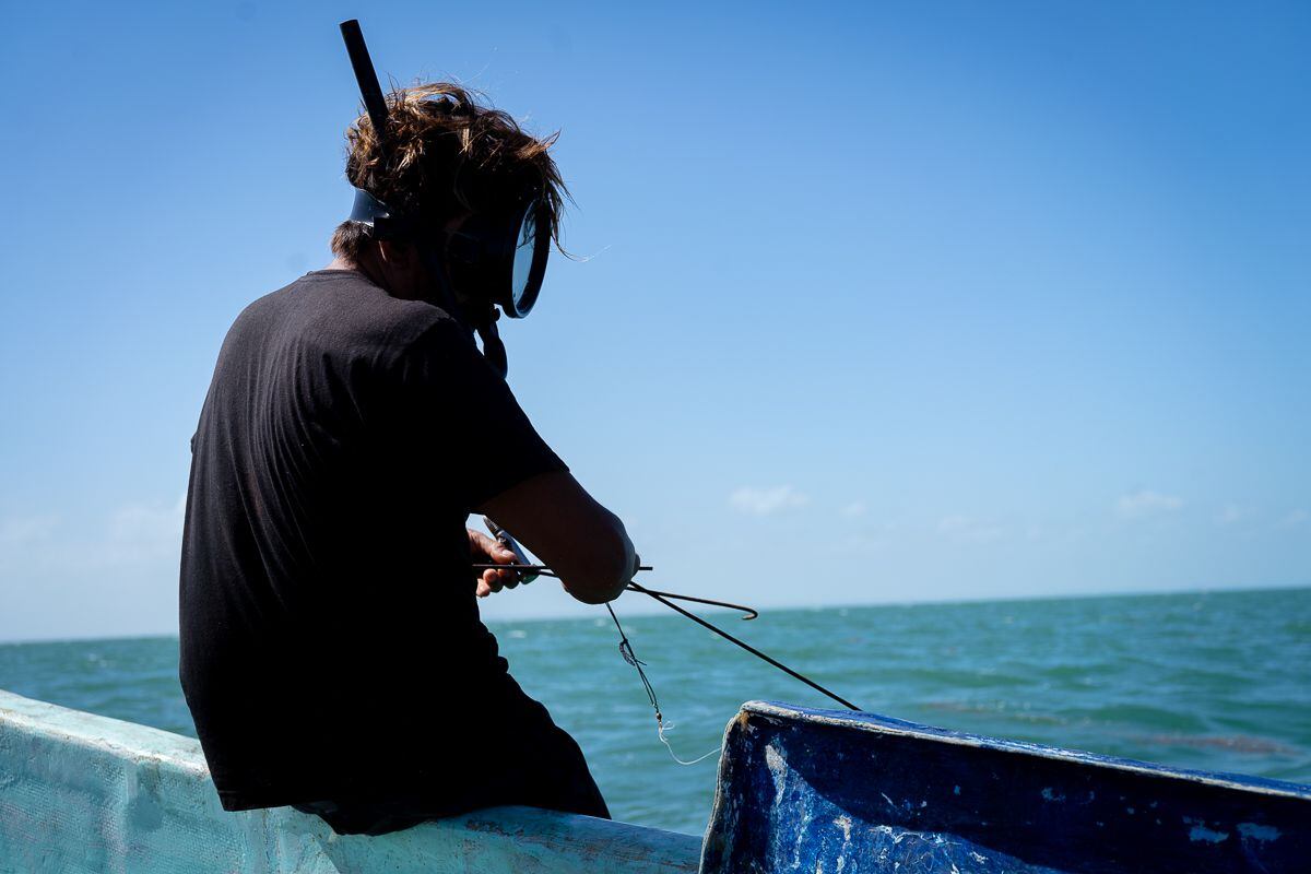 Un pescador irregular se prepara para bucear a pulmón, ya que la compresora con la que pretendía trabajar no funcionó. 