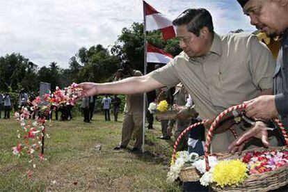 El presidente indonesio, Susilo Bambang Yudhoyono, arroja pétalos sobre tumbas de víctimas en Lambaro.