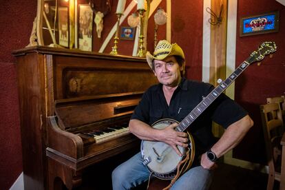 Greg Ryan, músico multinstrumentalista, fue uno de los primeros estadounidenses en traer la cultura 'country' a España. En la imagen, posa con uno de sus banjos en su local, El Barn d'en Greg, en la localidad de Rubí, en Barcelona