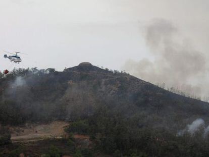 Un helicoptero durante las funciones de extinci&oacute;n del incendio forestal en Ceuta este lunes.