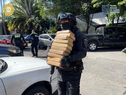 Un oficial de policía carga algunos de los paquetes de cocaína incautados el 26 de julio de 2022, en Ciudad de México.