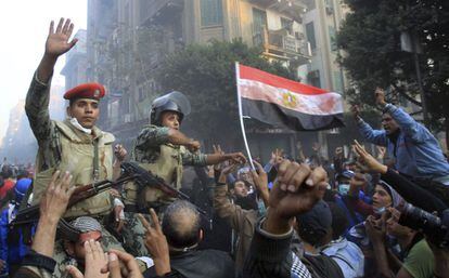 Soldados egipcios aupados a hombros se interponen entre los policías antidisturbios y manifestantes durante los incidentes en las proximidades de la plaza Tahrir de El Cairo, el 22 de noviembre de 2011.