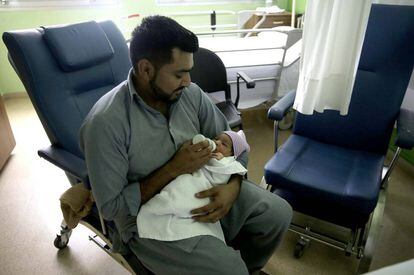Un padre pakistaní da este martes el biberón a su bebé recién nacido en San Sebastián.