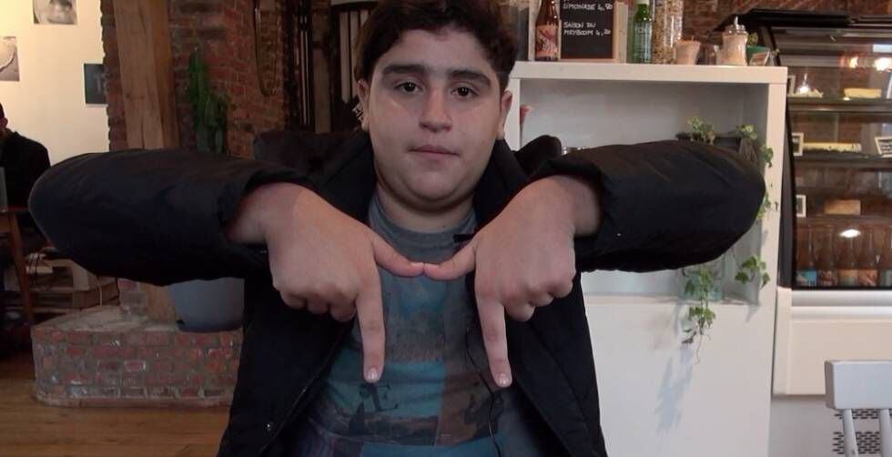 Aziz Benhamou, rapero y estudiante, hace la M con las manos, el gesto con que los jóvenes del barrio se refieren a Molenbeek.