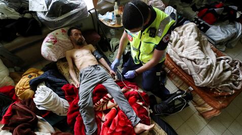 Youssef Bouzidi, un solicitante de asilo marroquí que está en huelga de hambre durante más de un mes, es examinado por un trabajador de la salud en una habitación en el campus de la universidad de Bélgica ULB, el 29 de junio de 2021.