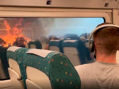 Los viajeros del tren Madrid-Ferrol atraviesan un tramo del viaje con llamas a ambos lados de la vía este lunes.