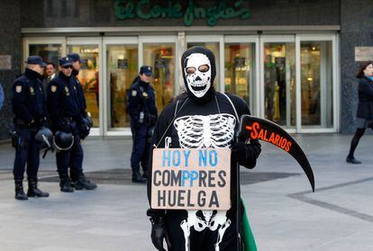 Un manifestantes, disfrazado de Muerte, frente a unos grandes almacenes del centro de Madrid.