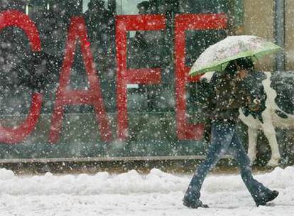 Una joven pasea bajo la nieve en el centro de Vitoria.
