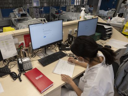 Una sanitaria del Hospital Clínic de Barcelona trabaja tomando notas a mano después del ciberataque, el lunes.