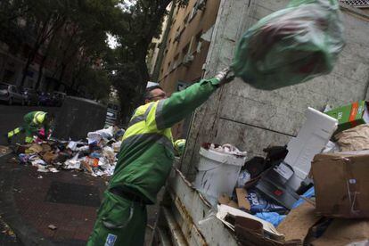 Un trabajador del servicio de limpieza viaria de Madrid limpia los restos de la huelga.