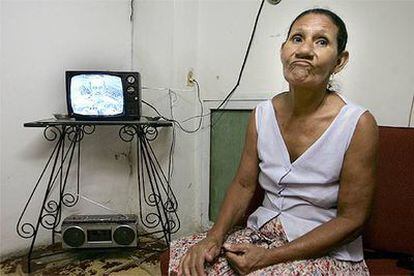 Una mujer cubana escucha el discurso en televisión del presidente Fidel Castro.
