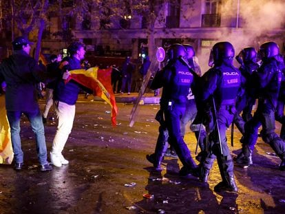 Un joven, bandera en mano, se encara con la policía al término de la manifestación en Ferraz, este martes.