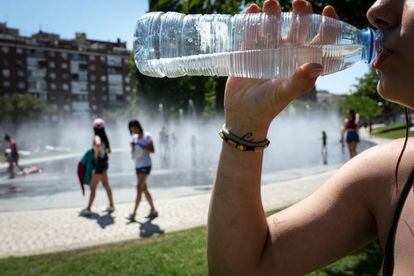 Una mujer bebe agua embotellada en el parque Madrid Río.