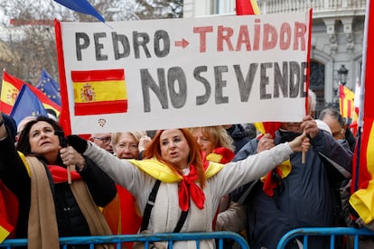 Una manifestante sostiene un cartel contra el presidente del Gobierno, Pedro Sánchez, este sábado en Madrid.