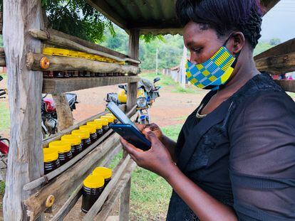 Una vendedora de miel usa su móvil en una pequeña aldea del condado de Baringo, en Kenia.