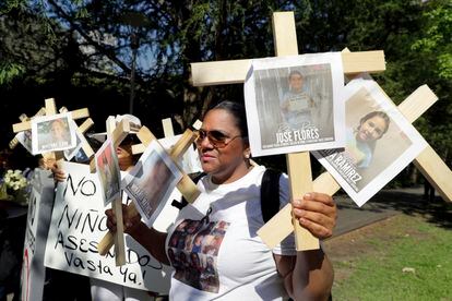Nancy Pablo, de la Alianza Latina International, sostiene cruces con fotos de las víctimas del tiroteo de la escuela primaria Robb.