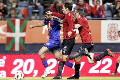 Diego Costa conduce el balón perseguido por Lolo y Monreal.