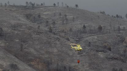 Un helicóptero sobrevuela una zona de monte devastada en el témino de Bejís, en Castellón.