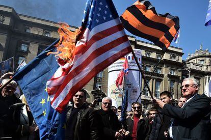 El ultranacionalista serbio (a la derecha) quema la bandera de EEUU en una manifestación el 24 de marzo en Belgrado.
