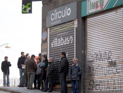 Varias personas hacen cola ante una oficina del INEM en Bilbao.