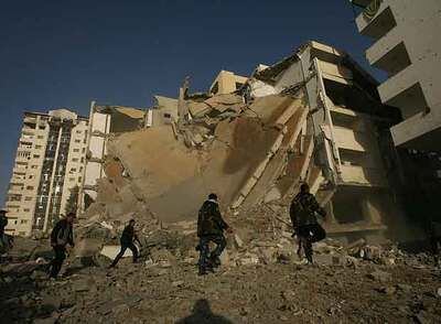 Un grupo de palestinos frente al edificio bombardeado en Gaza.