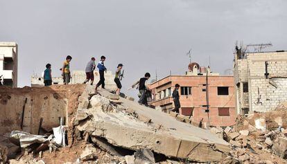 Un grupo de ni&ntilde;os juega sobre las ruinas de un edificio al sur de Damasco.