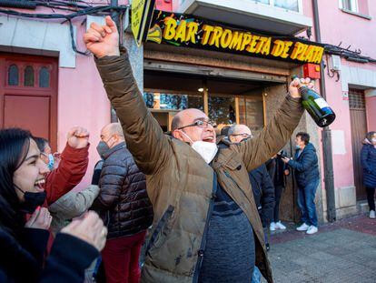 Uno de los agraciados celebra a las puertas del bar Trompeta de Plata el primer premio del sorteo extraordinario de la lotería del Niño, en Logroño.