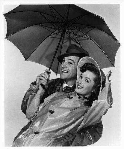 Gene Kelly y Debbie Reynolds posan junto a un paraguas en la película 'Cantando bajo la lluvia', en 1952.