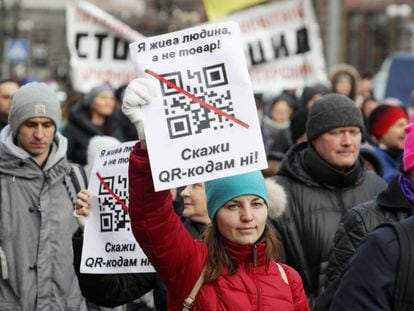 Una mujer sostiene una pancarta en una protesta contra la vacunación obligatoria para los trabajadores del sector público en Ucrania