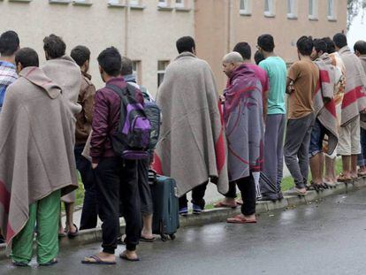 Un grupo de solicitantes de asilo permanece en el exterior de un centro de acogida tras un incendio en la localidad de Aue (Alemania), a mediados de 2015.