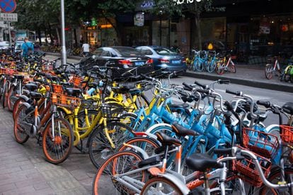 Decenas de bicicletas compartidas inundan las aceras de esta calle de Pekín.