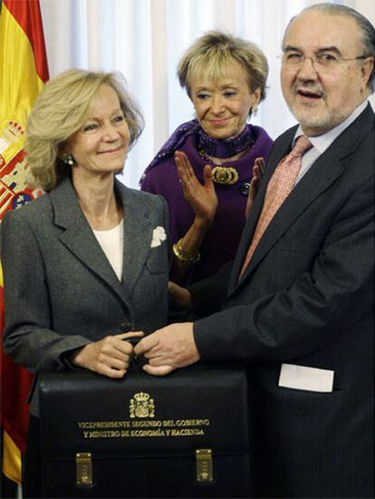 Elena Salgado se abraza a su predecesor, Pedro Solbes, tras el traspaso de carteras junto a la atenta mirada de la vicepresidenta De la Vega.