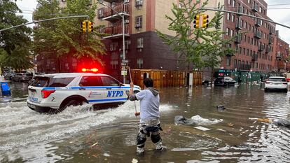 Un hombre intenta drenar una alcantarilla en Brooklyn.