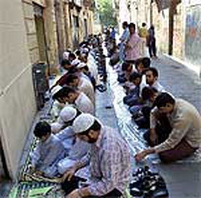 Un grupo de paquistaníes reza en el barrio del Raval, Barcelona.