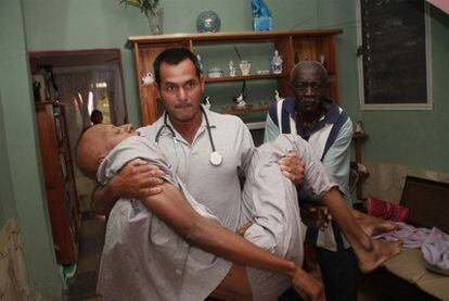 Un médico traslada a Fariñas tras sufrir éste un desmayo, ayer en su casa de Santa Clara.