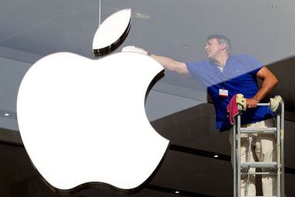 Un hombre limpia el logotipo de Apple en una tienda de Barcelona