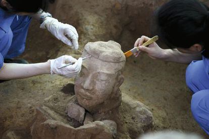 Arqueólogos chinos trabajan en la limpieza de uno de los nuevos guerreros de terracota recién descubiertos en Xian (China).