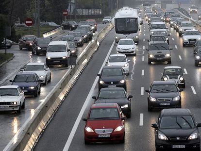 Atasco en la A6, hoy en Madrid, durante la lluvia.