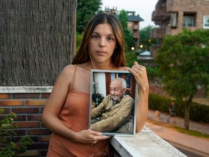 Nydia sujeta una foto de su abuelo, Mariano, fallecido el pasado enero, en su casa en Majadahonda, Madrid.