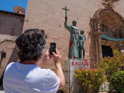Un hombre fotografía la estatua dedicada en Palma a Fray Junípero Serra, con la pintada en rojo, esta mañana.