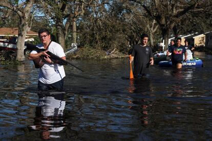 Un hombre caminaba con una escopeta por una calle inundada de North Port (Florida), el viernes.