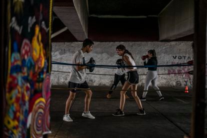 Varios jóvenes boxean en un ring ubicado bajo un puente en Azcapotzalco, Ciudad de México.