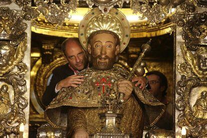 Francisco Camps abraza la estatua del apóstol Santiago. Al fondo, Núñez Feijóo.