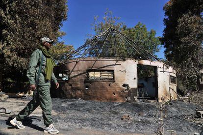Un soldado malinense camina frente a un edificio del Ejército, convertido en posición rebelde y destruido durante un bombardeo.